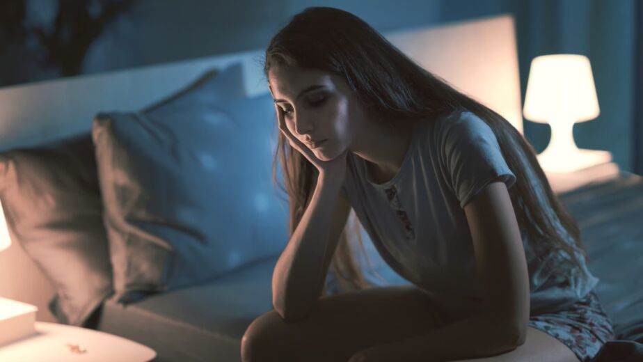 Mujer despierta de noche por estrés crónico y sueño interrumpido